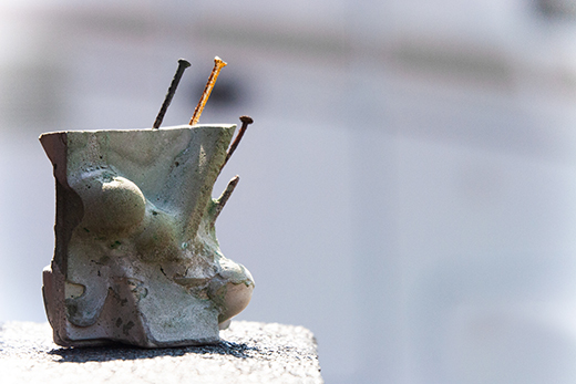 Skulptur in Zement mit rostige Nägel